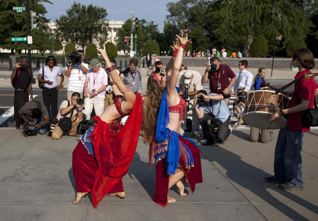 News photographers photograph a group of belly dancers 