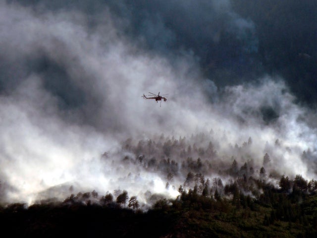 A helicopter flies over the Waldo Canyon fire as it continues to burn June 27, 2012, in Colorado Springs, Colo. 