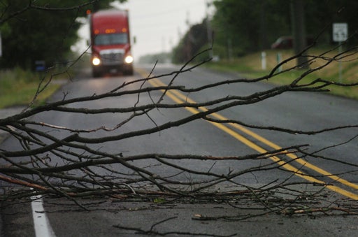A semitrailer slows to negotiate tree limbs across Indiana 18 east of Converse, Ind 