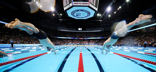 Davis Tarwater, left, and Michael Phelps dive at the start of men's 100-meter butterfly  