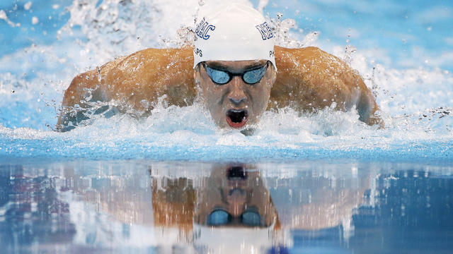 Michael Phelps swims to victory in the men's 100-meter butterfly  