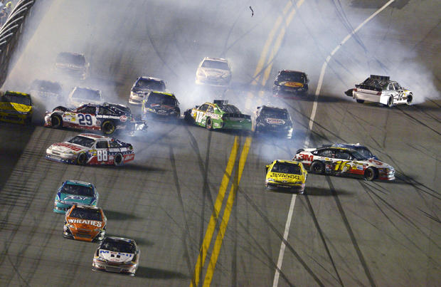 Tony Stewart heads to the finish line for the victory as a multi-car crash takes place  