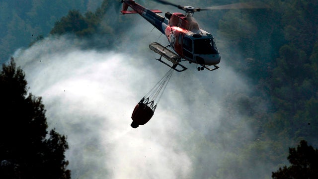 A helicopter works above a fire in Boadella, Spain, July 24, 2012. 