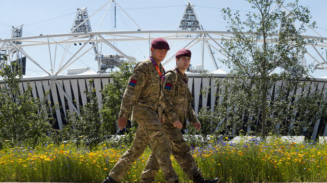 Soldiers walk past the Olympic Stadium in London 