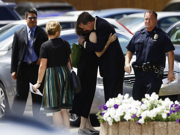 Colorado Governor John Hickenlooper (3rd R) hugs his wife Helen Thorpe after leaving the memorial service for their Gordon Cowden at Pathways Church July 25, 2012 in Denver, Colorado. 