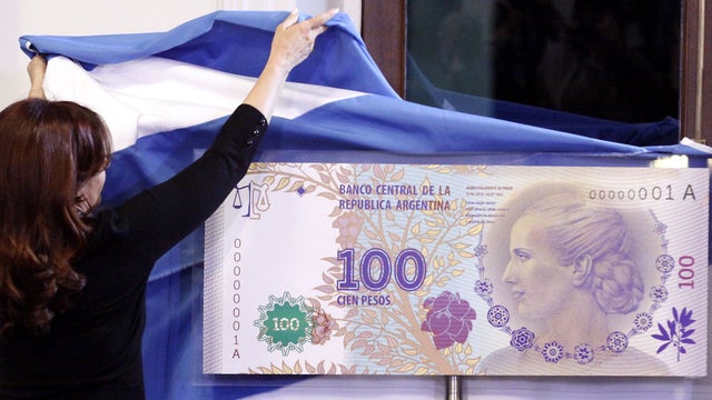 Argentinian President Cristina Fernandez unveils an archetype of the new 100-pesos banknote bearing the profile of former first lady Maria Eva Duarte de Peron, better known as "Evita," during a ceremony at government palace in Buenos Aires, Argentina, Wed 