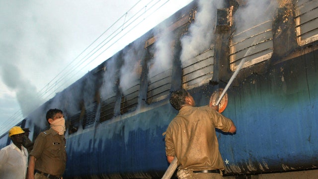 Indian fire official douses fire coming out from a coach of a passenger train 
