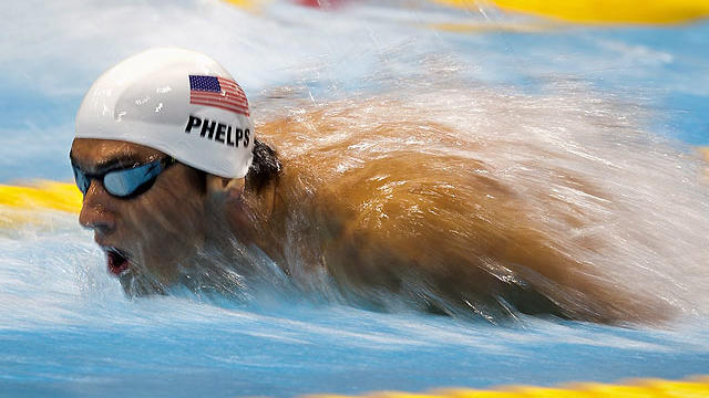 Michael Phelps of the USA explodes out of the water in his swimming heat in the Men's 200m Butterfly at the Olympic Games in London on July 30, 2012.  