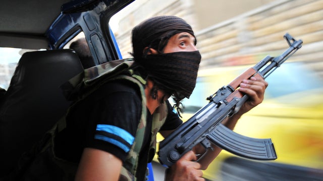 Syrian rebels hunt for snipers after attacking the municipality building in the city center of Selehattin, Syria, July 23, 2012, during fights between rebels and Syrian troops. 