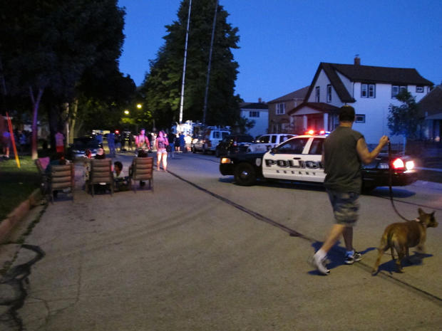Police and residents near a home being searched after the Wisconsin Sikh temple shooting 