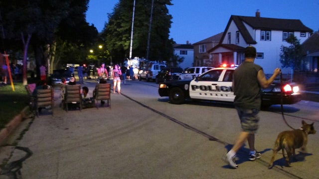 Police and residents near a home being searched after the Wisconsin Sikh temple shooting 