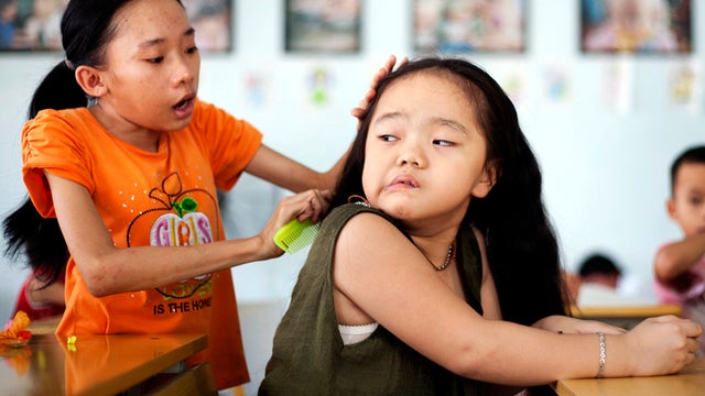 Ho Thi Lang, left, combs Ngo Diep Uyen's hair after her nap at a rehabilitation center in Danang, Vietnam, Aug. 7, 2012. The children were born with physical and mental disabilities that the center's director said were caused by their parents' exposure to 
