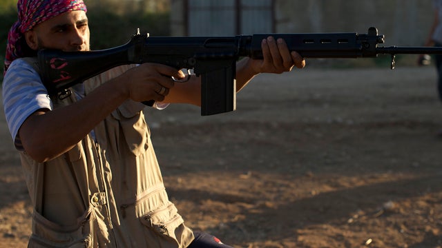 Syrian rebel fighters shoot during target practice in Daraya, Syria, Aug. 4, 2012. 