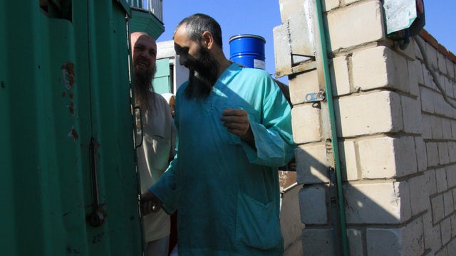 Members of an underground sect in Russia stand outside their compound 