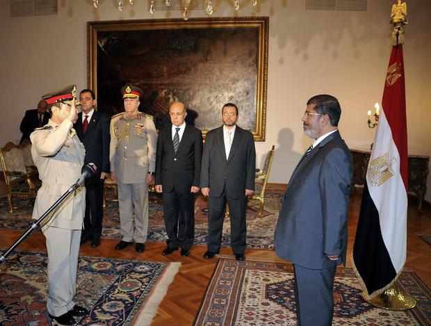 Egyptian President Mohammed Morsi, right, swears in newly-appointed Minister of Defense, Lt. Gen. Abdel-Fattah el-Sissi, left, in Cairo, Egypt, Sunday, Aug. 12, 2012. 