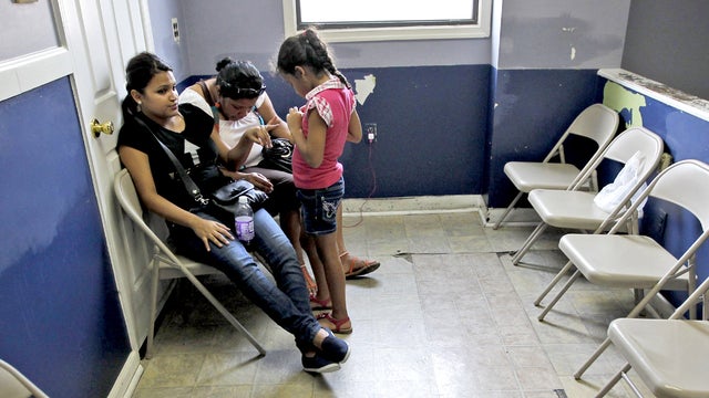 Mayra Rivera, center, with her children, Aixa Martinez, 18, left, and Aryam Rivera, right, from Philadelphia, wait inside the Embassy of Honduras Consulate Section, in Washington, Tuesday, Aug. 14, 2012.  