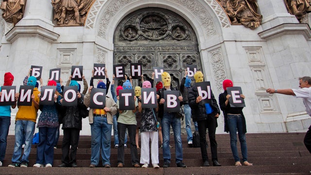 Pussy Riot supporters holding Cyrillic letters reading "Blessed are The Merciful" 