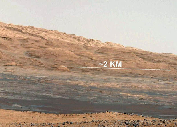 This image (cut out from a mosaic) shows the view from the landing site of NASA's Curiosity rover toward the lower reaches of Mount Sharp, where Curiosity is likely to begin its ascent through hundreds of feet (meters) of layered deposits. The lower several hundred feet (meters) show evidence of bearing hydrated minerals, based on orbiter observations. The terrain Curiosity will explore is marked by hills, buttes, mesas and canyons on the scale of one-to-three story buildings, very much like the Four Corners region of the western United States.  A scale bar indicates a distance of 1.2 miles (2 kilometers).  Curiosity's 34-millimeter Mast Camera acquired this high-resolution image on Aug. 8, 2012 PDT (Aug. 9 EDT).  This image shows the colors modified as if the scene were transported to Earth and illuminated by terrestrial sunlight. This processing, called "white balancing," is useful to scientists for recognizing and distinguishing rocks by color in more familiar lighting.  Image credit: NASA/JPL-Caltech/MSSS 