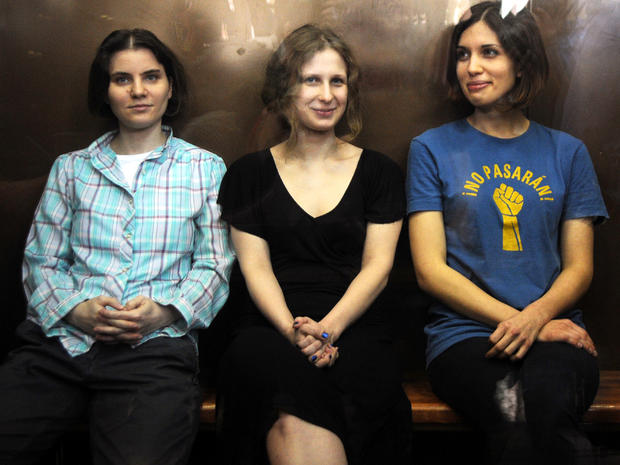 Members of the all-girl punk band Pussy Riot Yekaterina Samutsevich, left, Maria Alyokhina, center, and Nadezhda Tolokonnikova sit in a glass-walled cage during a court hearing in Moscow Aug. 17, 2012. 