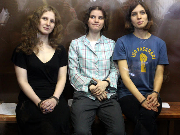Members of the all-girl punk band Pussy Riot, Maria Alyokhina, left, Yekaterina Samutsevich, center, and Nadezhda Tolokonnikova, sit in a glass-walled cage after being sentenced in Moscow Aug. 17, 2012. 