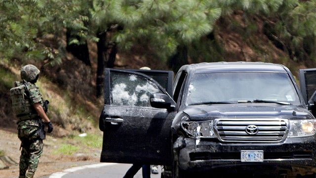 An armored U.S. Embassy vehicle is checked by military personal after it was attacked by unknown assailants on the highway leading to the city of Cuernavaca, near Tres Marias, Mexico, Friday, Aug. 24, 2012. 