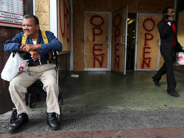 George Julien rests after shopping in a boarded-up store that remained open on Canal Street in New Orleans Aug. 28, 2012, as Hurricane Isaac beared down on the city. 
