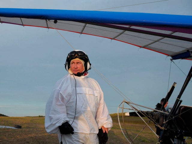 Russian President Vladimir Putin stands beside a motorized hang glider 