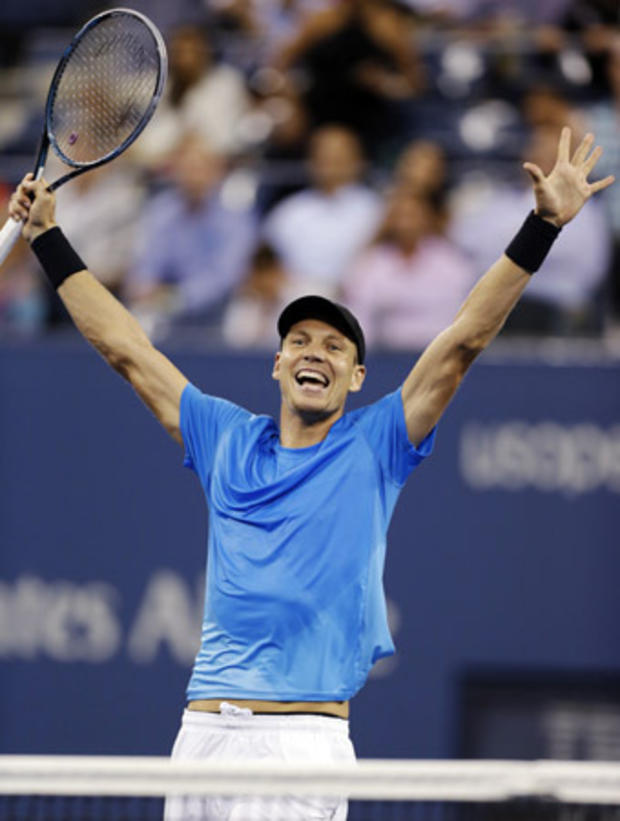 Tomas Berdych raises his arms after defeating Roger Federer 