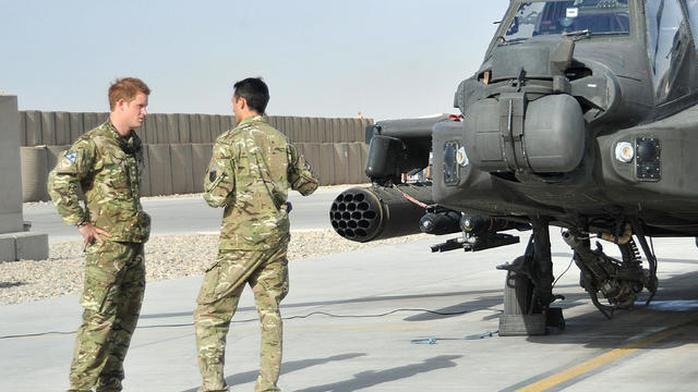 Prince Harry and a fellow soldier near an Apache helicopter in Afghanistan 