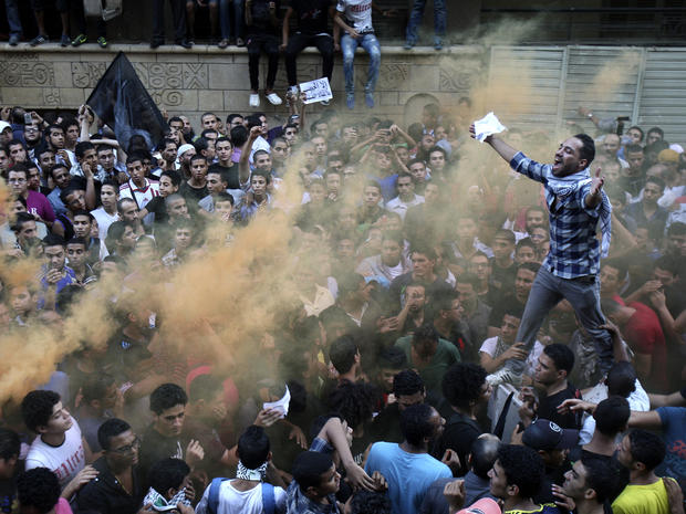 Protesters chant slogans amid orange smoke outside the U.S. Embassy in Cairo Sept. 11, 2012. 