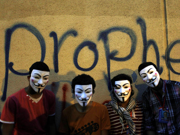 Egyptian protesters wearing Guy Fawkes masks pose in front of graffiti on a wall of the U.S. Embassy during a protest in Cairo Sept. 11, 2012. 