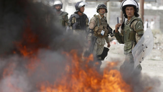 Afghan police stand by burning tires during a protest near the U.S. Camp Phoenix 