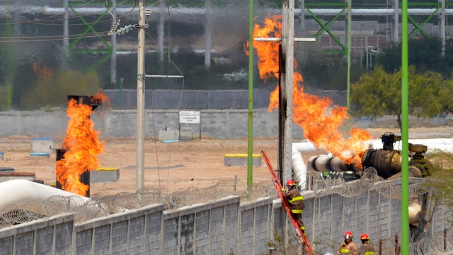 Firefighters climb ladder as they battle fire after explosion at gas pipeline distribution center in Reynosa, Mexico, near Mexico's border with United States 