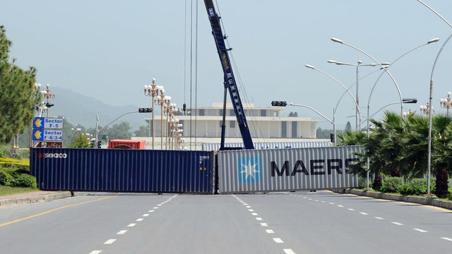Freight containers block a road leading to the Pakistani presidential palace and diplomatic enclave 