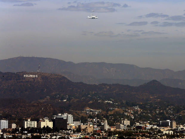 LOS ANGELES, CA - SEPTEMBER 21: The space shuttle Endeavour, sitting on top of NASA's Shuttle Carrier Aircraft or SCA, flies near the Hollywood sign on September 21, 2012 in Los Angeles, California. The space shuttle Endeavour did a 4-1/2 hour tour over C 