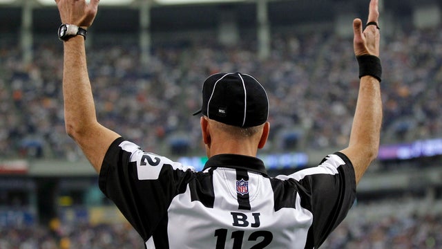 An official signals a touchdown during the second half of an NFL football game between the Minnesota Vikings and the Oakland Raiders in Minneapolis Nov. 20, 2011. 