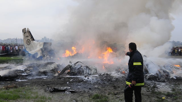 Firemen battle flames from the wreckage of the Sita Air Dornier plane crash 