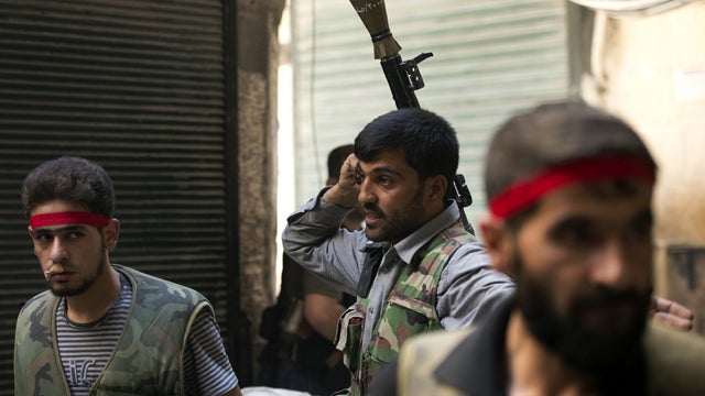 Syrian rebel fighters take their position during fighting with government troops in the old city of Aleppo, Syria, Sept. 28, 2012. 