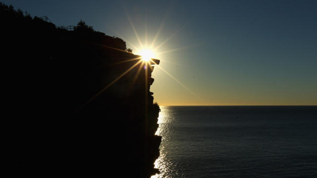 A cliff is seen at sunrise. 