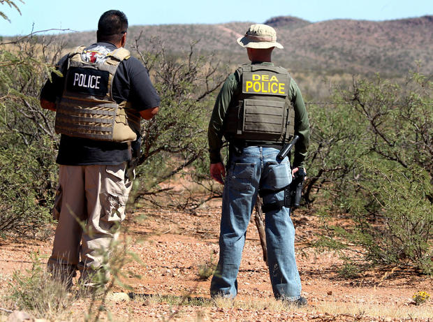 Det. Bill Silva, left, with the Bisbee Police Department, and an unnamed agent with the Drug Enforcement Administration patrol a fence line east of Naco, Ariz., after a Border Patrol agent was killed early Tuesday, Oct. 2, 2012. 