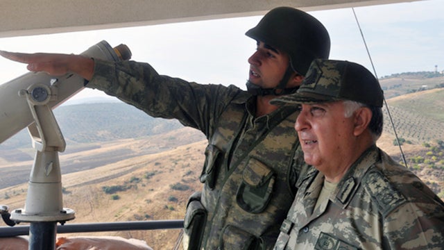 Turkish Chief of Staff Gen. Necdet Ozel, right, listens to a commander during his tour of the military along the border with Syria in Hatay, Turkey, Tuesday, Oct. 9, 2012.  