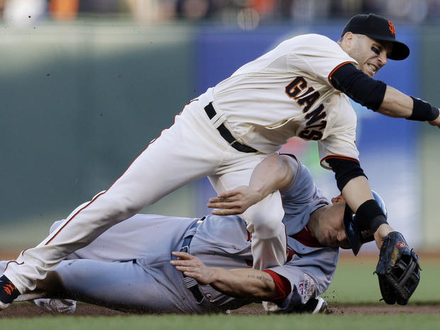 San Francisco Giants second baseman Marco Scutaro grimaces as his leg is caught under a sliding St. Louis Cardinals' Matt Holliday on a double play attempt during the first inning of Game 2 of baseball's National League championship series Monday, Oct. 15 