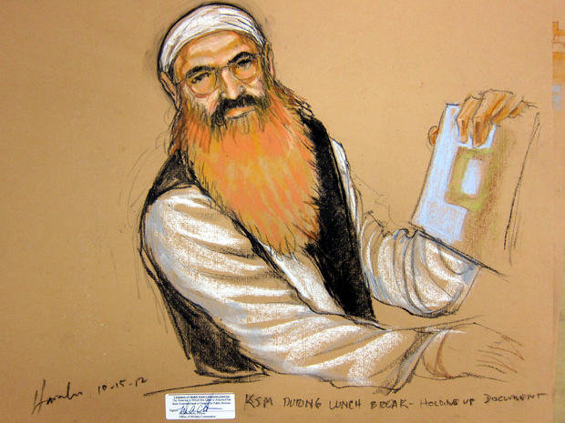 Khalid Sheikh Mohammed holds up a piece of paper during a court recess at a military tribunal pretrial hearing at the Guantanamo Bay Naval Base in Cuba, Oct. 15, 2012, in this picture of a sketch by courtroom artist Janet Hamlin and reviewed by the U.S. Department of Defense. 