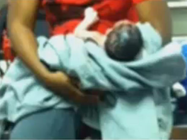 A new mom holds the baby boy she apparently gave birth to while riding on a Philadelphia subway train. 