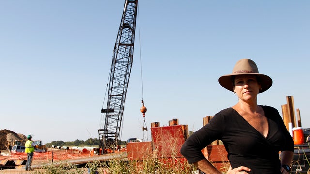 Julia Trigg Crawford stands on a road in front of a neighboring property to her family farm where work by TransCanada continues on a oil pipeline Thursday, Oct. 4, 2012, in Sumner, Texas. Oil has long lived in harmony with farmland and cattle across the T 
