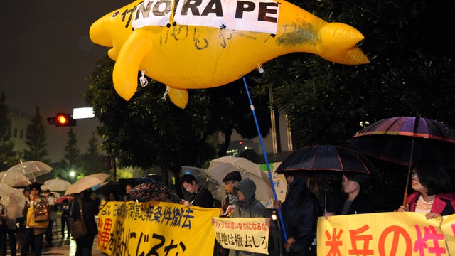 Some 50 civic group members hold banners protesting alleged rape of local woman by two U.S. servicemen in Okinawa 