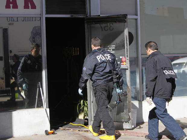 Police investigate at Fero's Bar and Grill in Denver on Wednesday, Oct. 17, 2012, where the bodies of a man and four woman were discovered after firefighters extinguished a fire at the bar early Wednesday morning. Police think the blaze was set to cover up their slayings. 