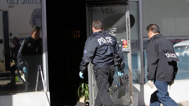 Police investigate at Fero's Bar and Grill in Denver on Wednesday, Oct. 17, 2012, where the bodies of a man and four woman were discovered after firefighters extinguished a fire at the bar early Wednesday morning. Police think the blaze was set to cover u 
