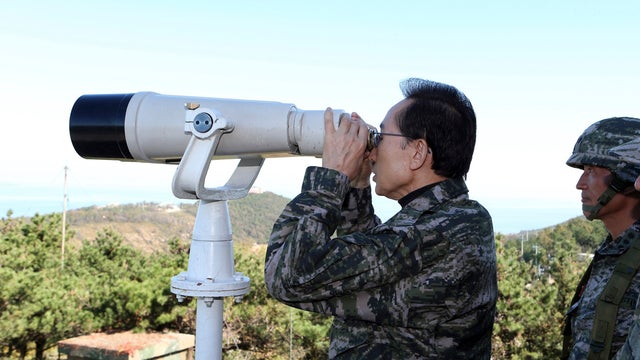 Minister Kim Kwan-jin, right, stands by on Yeonpyeong Island near the Yellow Sea border with North Korea, South Korea, Thursday, Oct. 18, 2012. The island was bombarded in the North Korea's shelling attack in November 2010, leaving two South Korean Marine 