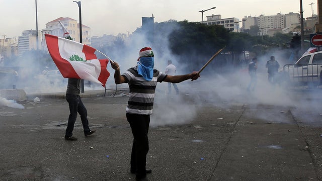 Lebanese supporter of March 14 movement, which opposes Syrian regime of President Bashar al-Assad, demonstrates waving his national flag as other protesters tried to storm governmental palace, after funeral of top intelligence chief General Wissam al-Hass 